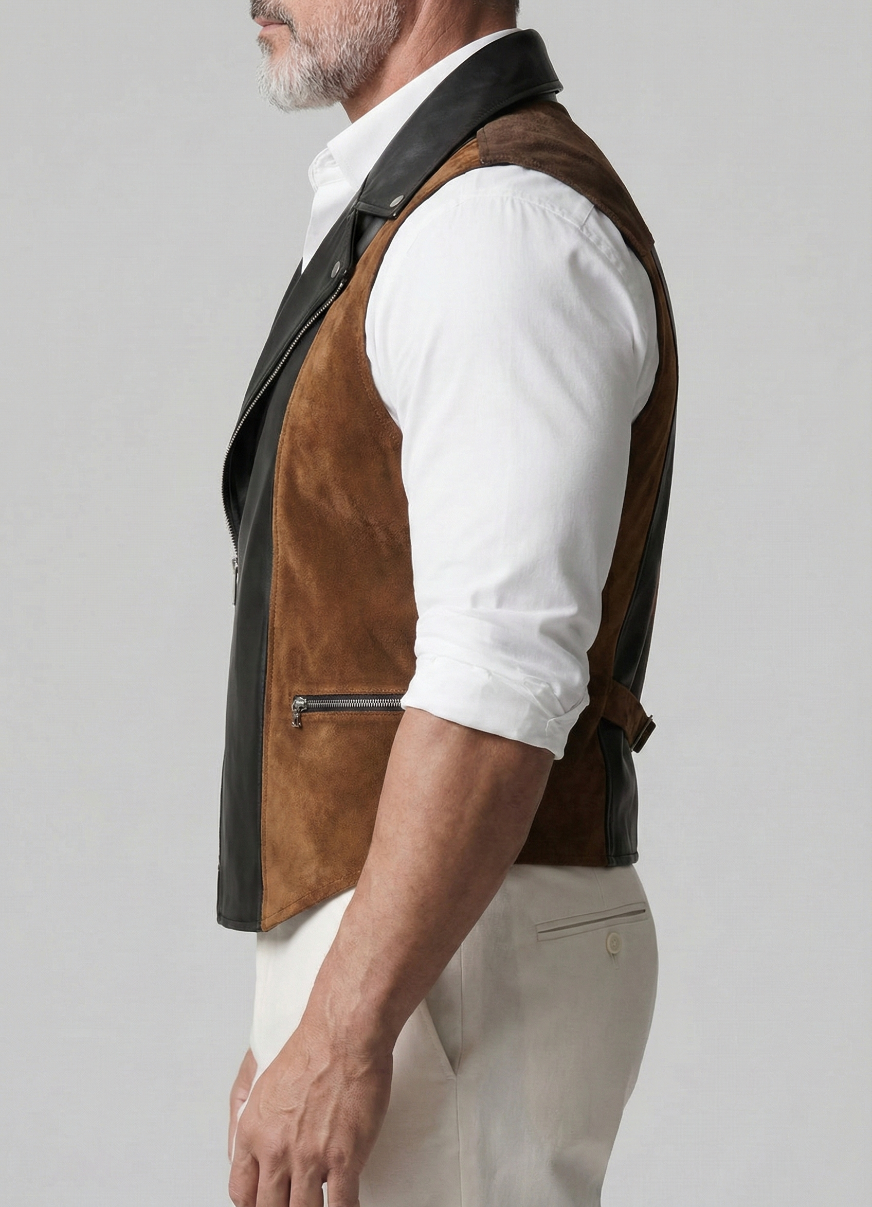 Man wearing a brown leather vest over a white shirt on a gray background